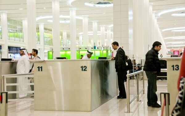BA6WCB People at Immigration in Dubai International Airport United Arab Emirates
